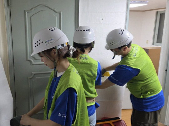 현대엔지니어링 집수리봉사단이 지난 7일 서울시 노후주택에서 장판을 시공하는 모습. [현대엔지니어링 제공]